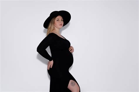 Moderne Umstandsmode: Eine Frau in einem eleganten Umstandskleid, das ihren Babybauch betont.