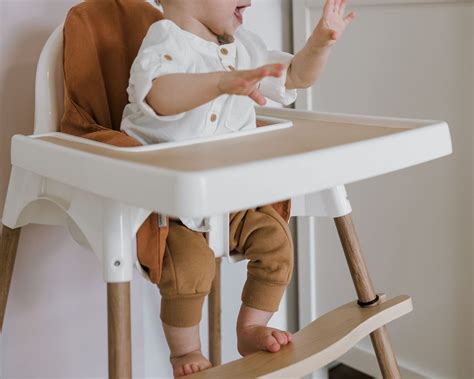 Ein Kind sitzt im IKEA ANTILOP Hochstuhl mit Tablett und isst.