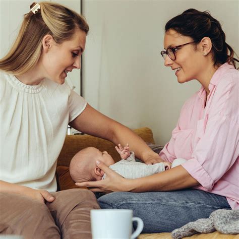 Hebamme im Gespräch mit einer jungen Mutter und ihrem Baby