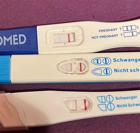 Vergleich von Schwangerschaftstests mit rotem und blauem Farbstoff, die eine schwache Linie zeigen.