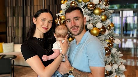drei Personen (Anna, Sargis und ihr Sohn Levi) halten einen positiven Schwangerschaftstest in den Händen, lächelnd und glücklich