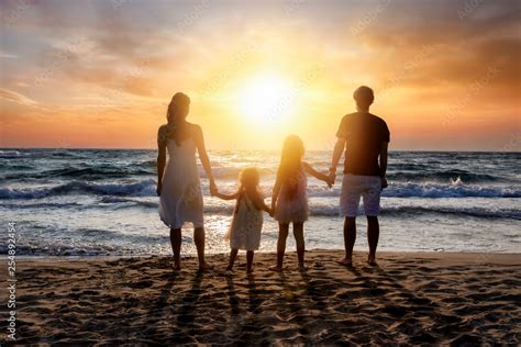 Familie genießt den Sonnenuntergang an einem Strand in Thailand