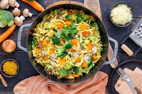 Eine appetitliche Nahaufnahme eines bunten Nudelsalats mit frischen Kräutern und Gemüse