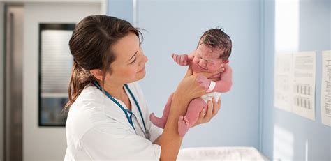 Foto einer Hebamme, die mit einer frischgebackenen Mutter und ihrem Baby spricht