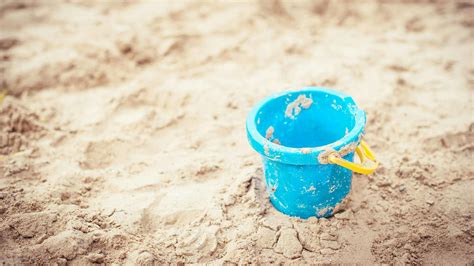 Sonniger Strand mit Familien, die im Sand spielen und im Meer planschen