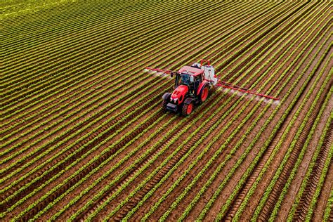 Fotografie von landwirtschaftlichen Maschinen, die organischen Dünger auf einem Feld verteilen.