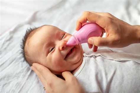 Baby, dem die Nase mit einem Nasensauger gereinigt wird