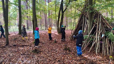 Eine Gruppe von Kindern und Eltern, die im Wald spielen und basteln.