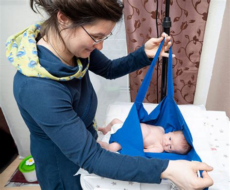 Eine Hebamme unterstützt eine frischgebackene Mutter mit ihrem Neugeborenen.