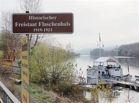 Detailaufnahme eines silbernen Flaschenkerzenhalters, der in einen Flaschenhals gesteckt wird, mit sichtbarer Tropfschale.