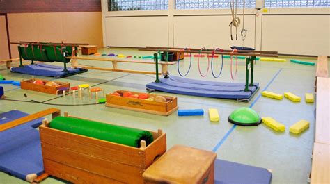Eine kreative Bewegungslandschaft für Kleinkinder in einem Wohnzimmer, bestehend aus Kissen, Tunneln und Kartons.