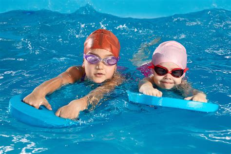 Kinder üben das Schwimmen mit Schwimmbrettern