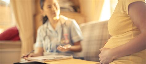 Hebamme im Gespräch mit einer jungen Mutter nach einem Verlust