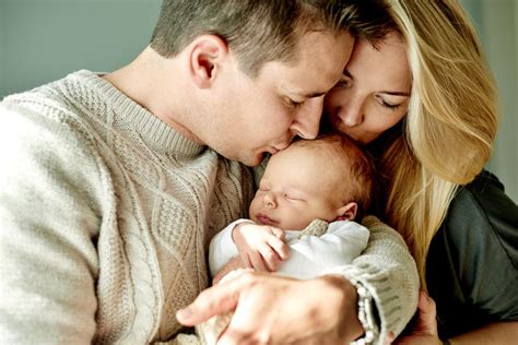 Ein zärtliches Bild von Eltern, die ihr Baby halten, mit einem sanften Lächeln.