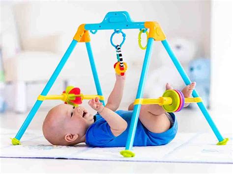 Illustration eines Babys, das neugierig auf einen bunten Spielbogen blickt.