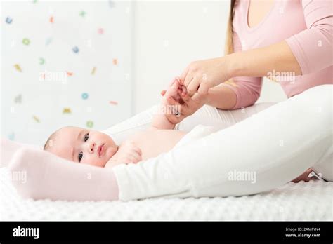 Eine Mutter, die ihrem Baby sanft den Bauch massiert.