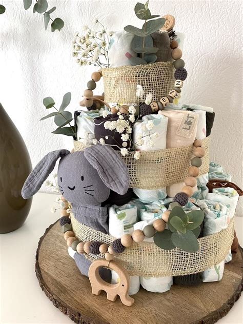 Beispiele für selbstgemachte Babygeschenke: Windeltorte, personalisierter Babybody, Baby-Mobile.