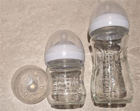 Vergleich von Babyflaschen aus Glas und Kunststoff, hervorgehobene Eigenschaften wie Gewicht und Bruchfestigkeit.