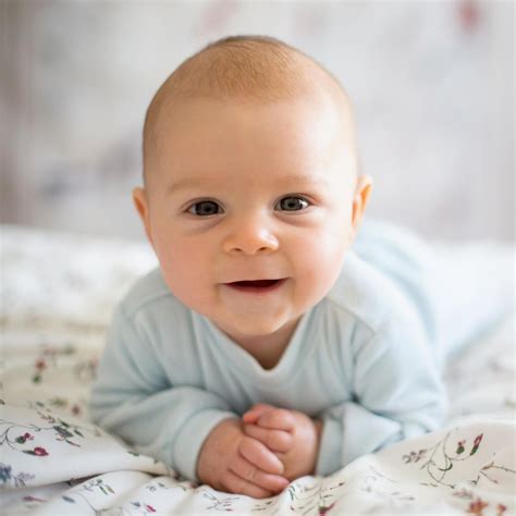 Ein niedliches Baby lächelt in die Kamera, umgeben von Windelprodukten von Pampers.