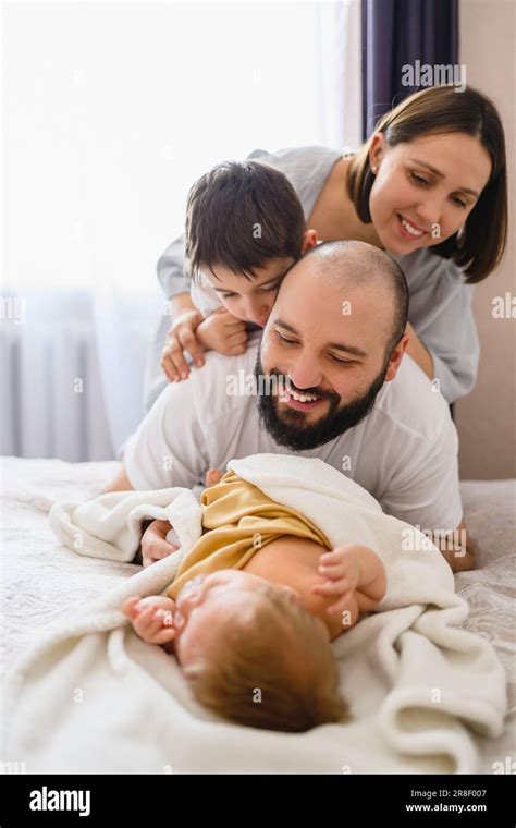Eine glückliche Familie mit ihrem Neugeborenen im Arm, aufgenommen in einer Klinikumgebung.