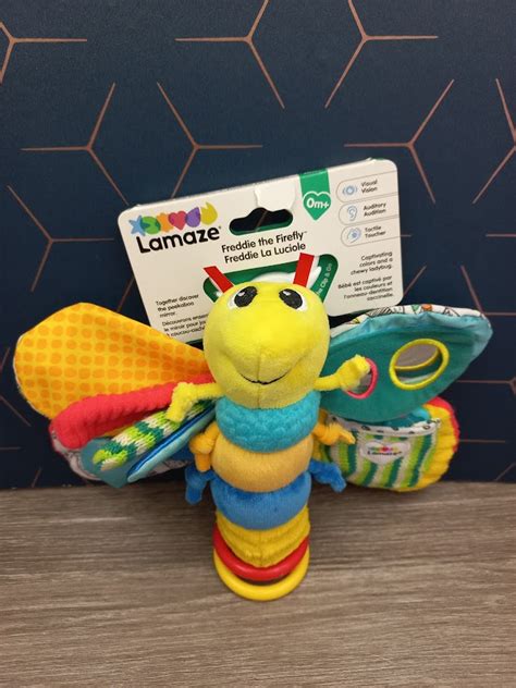 Eine bunte Auswahl an verschiedenen Babyspielzeugen, darunter Lamaze Freddie das Glühwürmchen, Spielbögen und Plüschtiere.