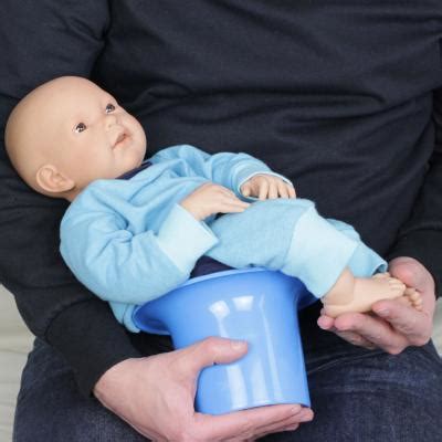 Schema, wie das Baby über dem Asia-Töpfchen gehalten wird.