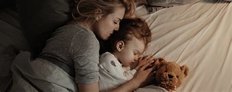 Eine Person, die beruhigend auf ein Kind in seinem eigenen Bett einredet.