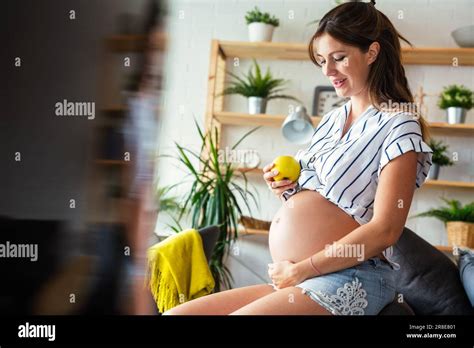 Eine schwangere Frau, die lächelnd ihren Bauch berührt, mit einem stilisierten Gefühl von Schmetterlingen