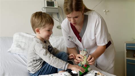 Kinderkrankenschwester hält eine kleine, bunte Frühchenmütze