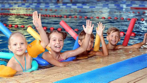Kinder lernen im Schwimmbad spielerisch, wie man sich im Wasser bewegt.