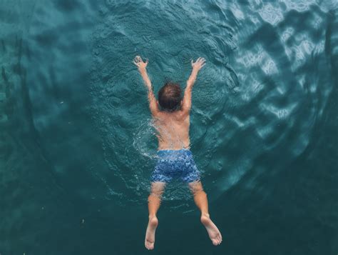 Eltern unterstützen ihr Kind beim Schweben auf dem Wasser.