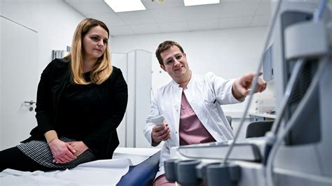 Frauenarzt bespricht mit schwangerer Patientin Medikamentenplan