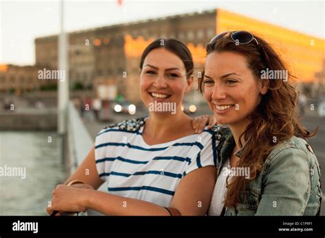 Zwei Frauen stehen auf einer Piazza in einer Schweizer Stadt, im Gespräch vertieft.