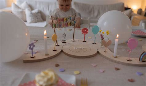 Eine festlich gedeckte Geburtstagstafel für ein einjähriges Kind mit Luftballons, Kerzen und Sesamsticks.