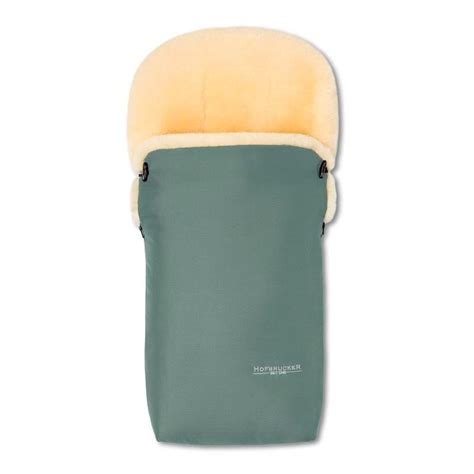 Ein Baby, das in einem weichen Lammfell-Fußsack von Hofbrucker in einem Kinderwagen liegt.