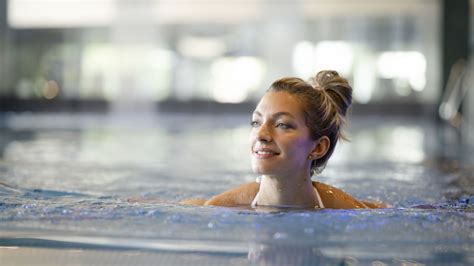 Eine Frau schwimmt entspannt in einem Schwimmbecken, was eine gelenkschonende und wohltuende Aktivität darstellt.