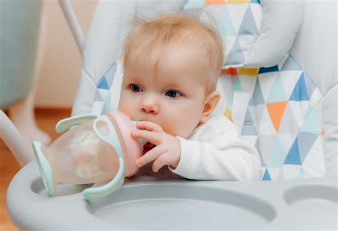 Ein Baby, das aus einer Tasse trinkt.