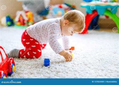 Kleines Baby, das mit bunten Spielzeugen interagiert