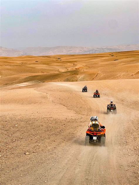 Eine Gruppe von Buggys fährt auf einer staubigen Piste durch eine felsige Landschaft.