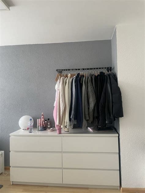 Eine Kommode mit seitlichen Ablageflächen des Wickelaufsatzes, auf denen Pflegeprodukte und Windeln liegen