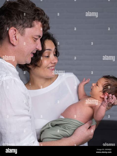 Eine Familie mit Neugeborenem und älterem Geschwisterkind, alle lächelnd