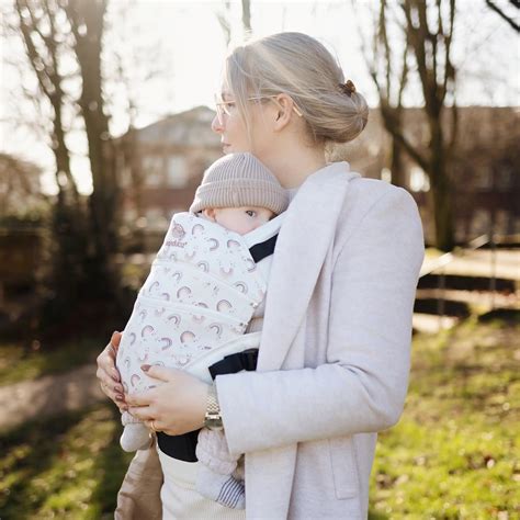 Eine Familie mit Baby in einer ergonomischen Babytrage auf einem Waldweg