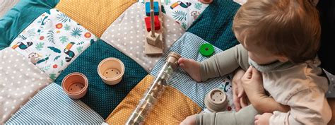 Baby krabbelt auf einer weichen, bunten Krabbeldecke