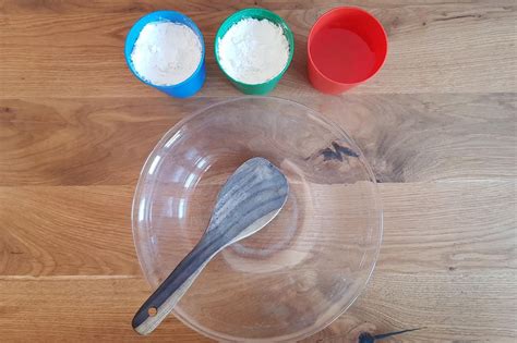 Nahaufnahme einer Hand, die langsam in eine Schüssel mit Oobleck taucht