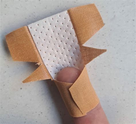 Kind mit Verband am Finger, das von einem Erwachsenen getröstet wird