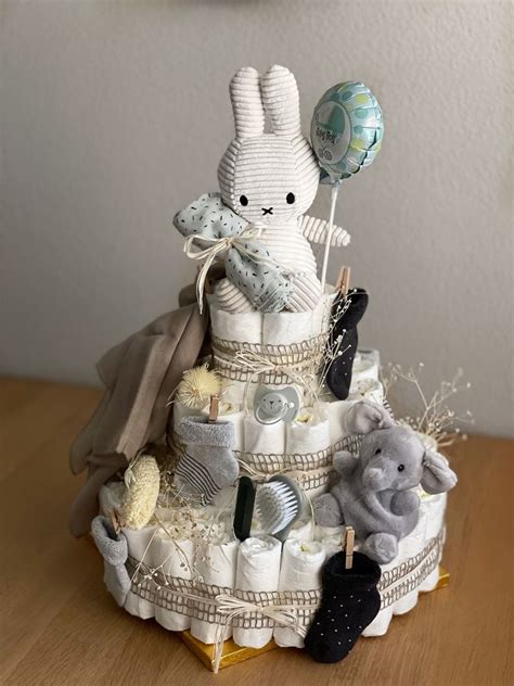Windeltorte in Form eines Elefanten mit Babykleidung und Kuscheltieren