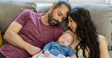 Eine glückliche Familie mit Neugeborenem im Arm, aufgenommen von einer professionellen Fotografin.