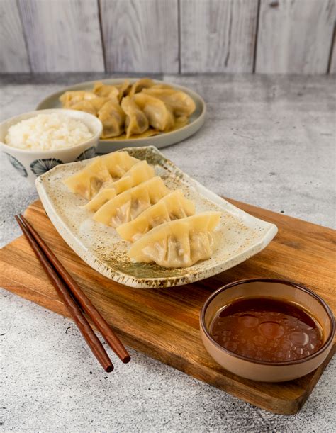 Ein Teller mit Gyoza, die mit Sojasauce serviert werden.