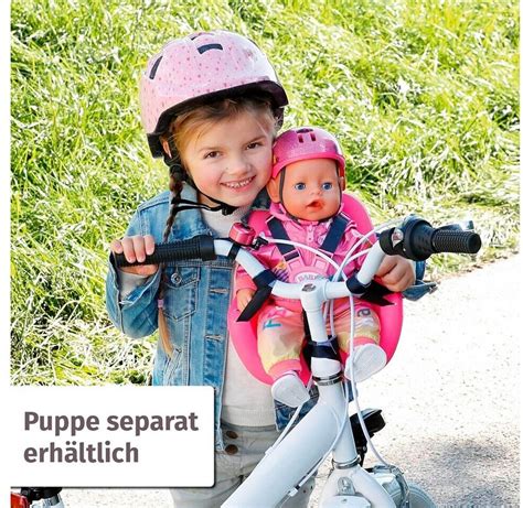 Kinder, die ihre BABY born Puppe in einem Fahrradsitz transportieren oder mit einem Roller fahren