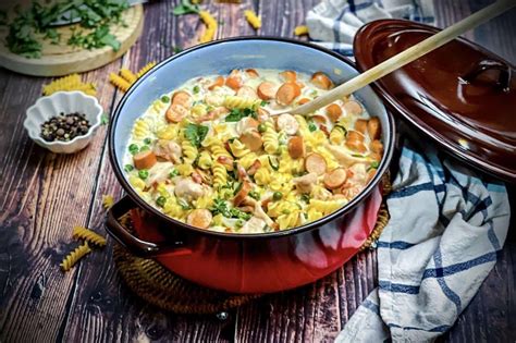 Foto von einer dampfenden Schweizer Hüttensuppe in einem Topf, garniert mit frischen Kräutern.